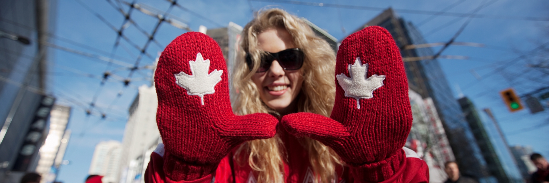 A woman with gloves with Canadian maple leafs on them.