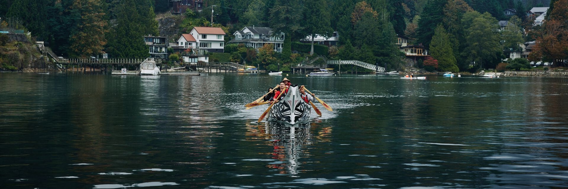 A family enjoying a guided canoe experience with Takaya Tours at Deep Cove